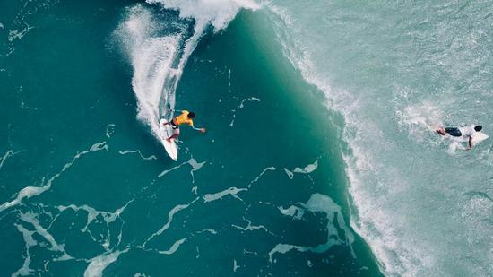 Surfers ride high to catch the perfect wave during the Hainan Surfing Open in December in Wanning, Hainan Province. (Photo provided to China Daily)